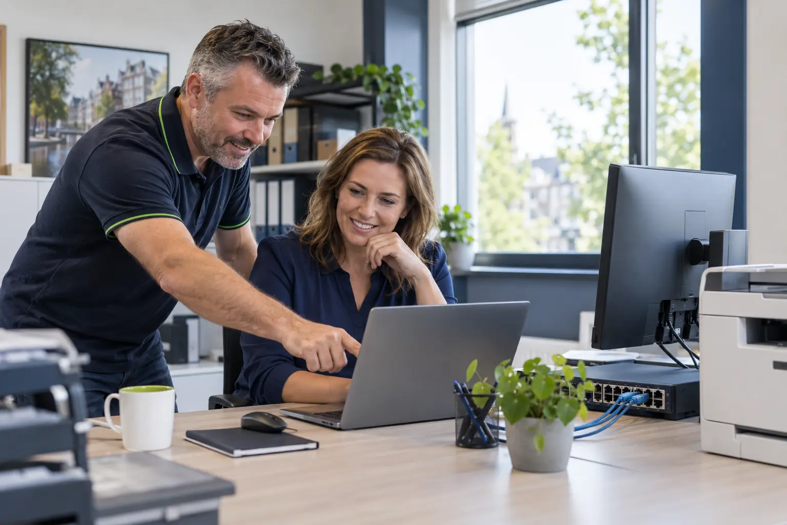 Een QCCS ICT-specialist helpt een mkb-klant op de werkplek
